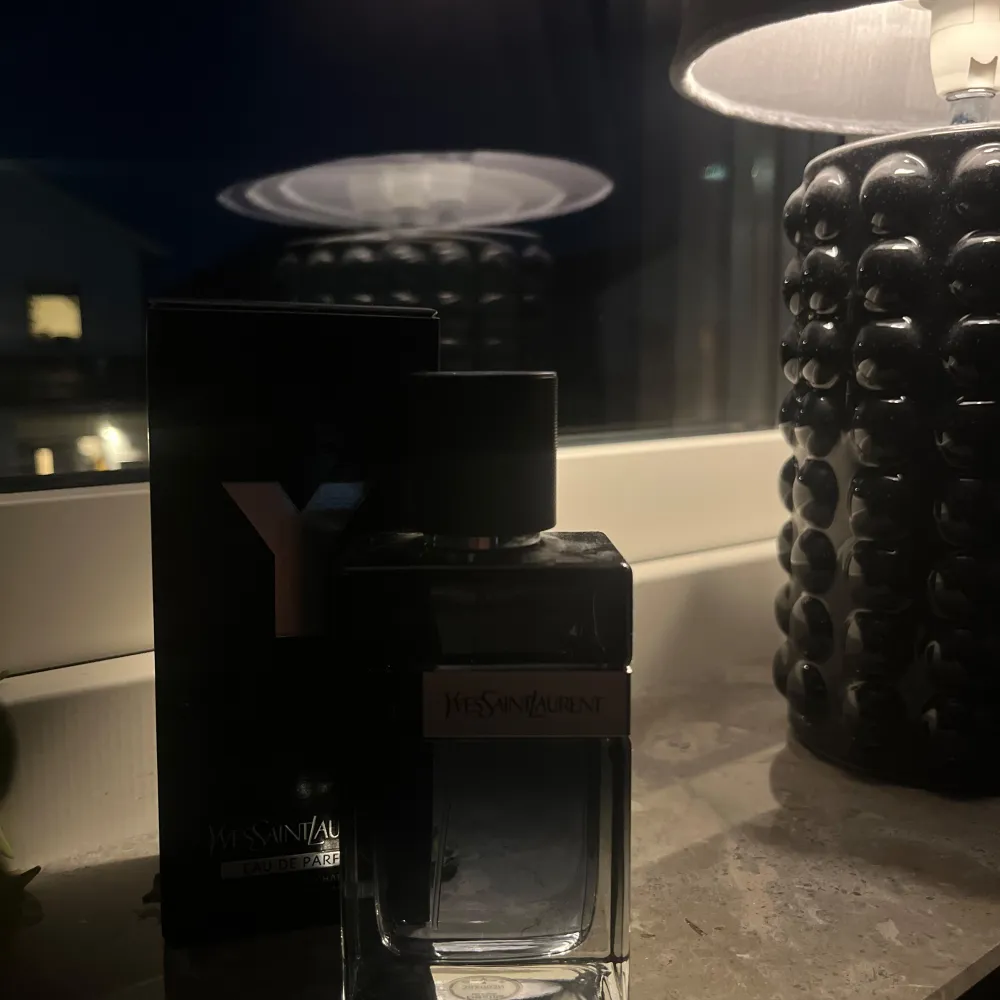 Säljer en elegant Yves Saint Laurent Eau de Parfum. Flaskan är stilren med en mörk tonad glasdesign och ett svart lock. Kommer i originalförpackning. Du ser på bild 3 hur mycket det är kvar. Kom med pris förslag!. Parfym.