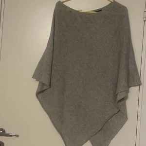 Grå poncho  - Säljer en grå poncho, är väldigt nopprig.