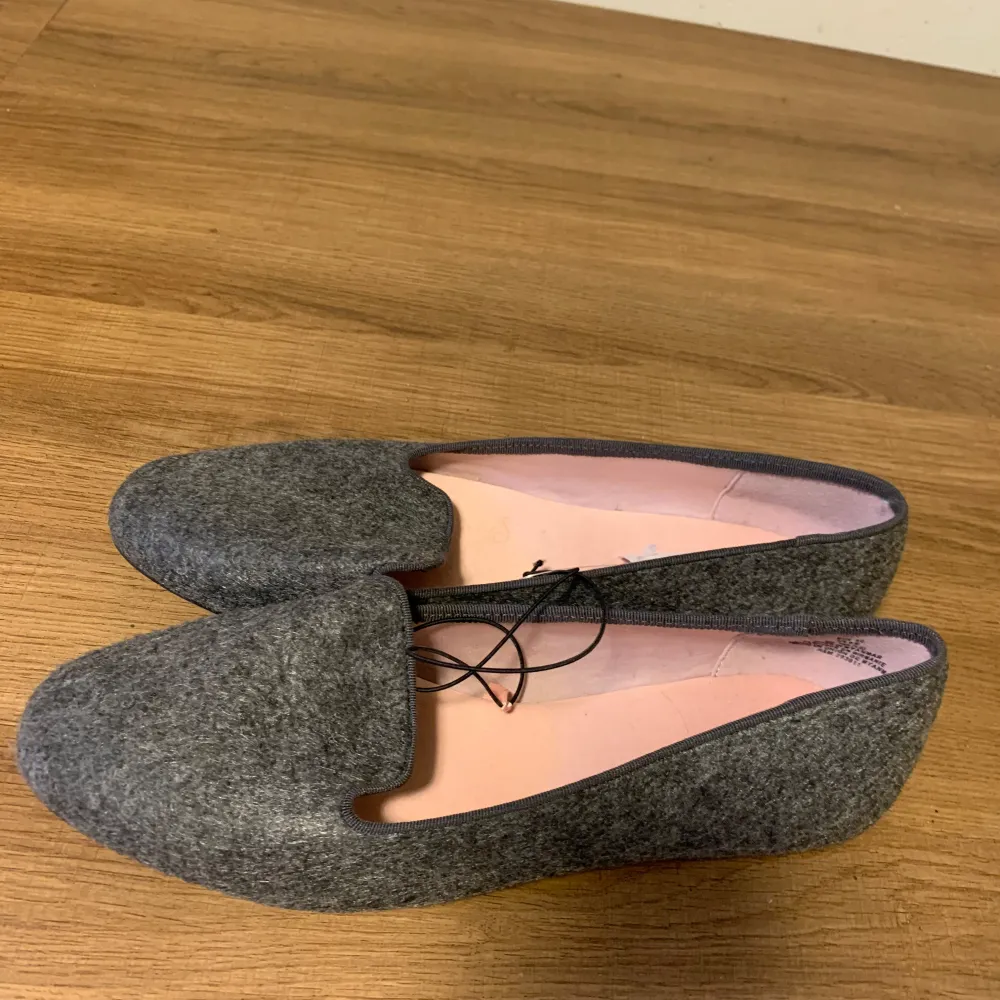 Snygga och stilrena grå loafers från H&M.Ett par loafers med ripsband runt kanten. Foder och innersula i satin. Yttersula i gummi. Mörk gråmelerad. Perfekt för vardagligt bruk.. Skor.