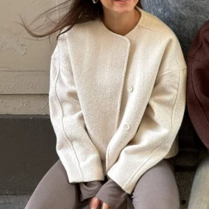 Beige ulljacka - Säljer en superfin beige ulljacka med en stilren design. Jackan har en rund hals och knappar framtill. Perfekt för höst och vår, och den har en normal passform. Den är långärmad och ger en elegant look till vilken outfit som helst. 