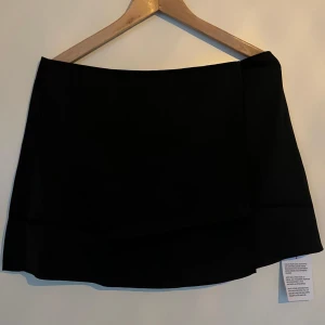 Svart sidenkjol - Svart sidenkjol i omlottmodell från ASOS i storlek 40. Oanvänd med prislapp kvar. Nypris 259