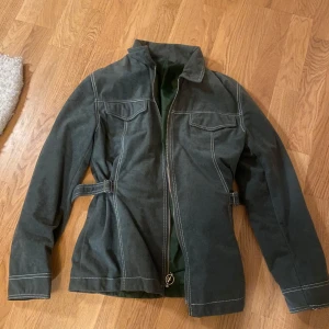 Grön jacka med dragkedja - Säljer en snygg grön jacka med dragkedja och vita sömmar. Jackan har en normal passform och är perfekt för höst och vår. 🩷Skriv för ytterligare bilder eller frågor