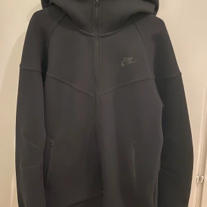 Nike tech fleece - Säljer en svart hoodie från Nike i mycket bra skick. Perfekt för höst och vår, och funkar lika bra till träning som till vardags. Orginalpris: 1500kr