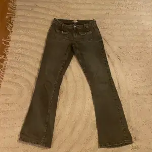 Säljer ett par grå jeans från Gina Tricot i storlek 170. De har en klassisk femficksdesign med knapp och dragkedja framtill. Byxorna har en rak passform och är perfekta för vardagsbruk. Materialet är slitstarkt och bekvämt, vilket gör dem till ett bra val för både skola och fritid.