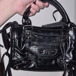 Svart väska - Snygg väska i nyskick, går att ha som cross body bag också. Medföljer en spegel som också är en korthållare som matchar väskan