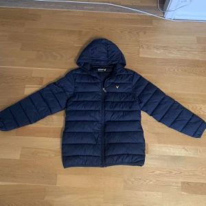 Lyle & Scott jacka - Jag har haft en nål i jackan. Se bild.  Jackan är mörkblå. 