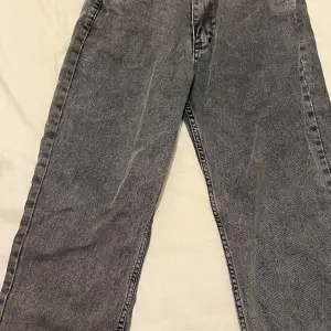 Säljer ett par grå jeans i storlek M. De har en klassisk design med raka ben och två bakfickor. Perfekta för en avslappnad stil och passar till det mesta. Skicket är bra och de är bekväma att bära. Perfekta för både vardag och fest! M storlek säljs för 70