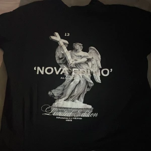 Svart T-shirt med tryck på rygg - Säljer den här T-shirten med ett snyggt tryck på ryggen då jag inte använder den. Nyskick. Storlek xs men skulle säga att den passar som S