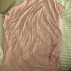 Rosa T-shirt från 157 - Säljer en söt rosa T-shirt från 157 i storlek XL. Tröjan  har en enkel design med korta ärmar och är perfekt för en avslappnad stil. Materialet känns mjukt och bekvämt mot huden. Den är väldigt fin och ringningen är till halsen cirka. Säljer den för använder aldrig.