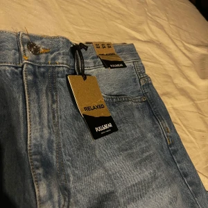 Blå jeans från Pull&Bear - Snygga blå jeans från Pull&Bear i relaxed fit. De har en klassisk femficksdesign och är tillverkade i denim. Perfekta för en avslappnad stil. US 44