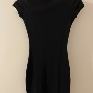 Svart ribbad klänning storlek xxs  - Snygg svart ribbad klänning från Fb sisters i en tight passform. Den har korta ärmar och en enkel design som gör den lätt att styla. Perfekt för en stilren look.
