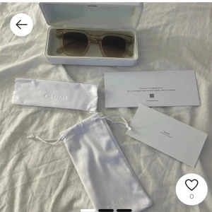 Beige solglasögon från Chimi04 eruc  - Snygga solglasögon från Chimi i en stilren beige färg. De har en fyrkantig form och kommer med ett praktiskt fodral och putsduk. Perfekta för att ge din outfit en trendig touch. 04 eruc. Skriv om egna bilder, allt med följer
