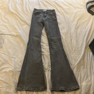 Grå flare jeans från Bershka - Snygga grå flare jeans från Bershka. De har en klassisk femficksdesign och är tillverkade i denim. Perfekta för en trendig look med sin utsvängda stil. Storlek 32.
