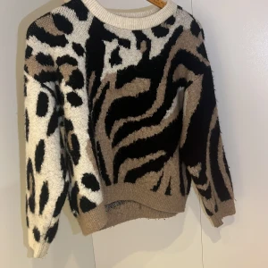 Leopard/zebra tröja - Säljer en unik tröja med mönster i beige, svart och vit. Tröjan har en normal passform och är långärmad, perfekt för att sticka ut i mängden. Den är tillverkad i ett mjukt material som känns skönt mot huden. kolla gärna in min profil för fler plagg 💓💓