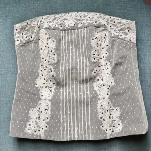 Grå tubtopp med spetsdetaljer -  Grå tubtopp med vita spetsdetaljer och broderier. Som ny! Passar xs-m