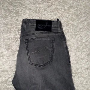 Grå jeans från Jacob Cohen - Snygga grå jeans från Jacob Cohen med knappgylf och klassisk femficksdesign. Perfekta för en stilren look. Byxorna är storlek 34 men uppsydda så passar 31-32. Kontakta vid eventuella frågor!