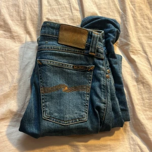 Blå jeans med broderad bakficka - Snygga blå jeans med broderad detalj på bakfickan. De har en klassisk femficksdesign och en bekväm passform. Perfekta för en avslappnad stil.