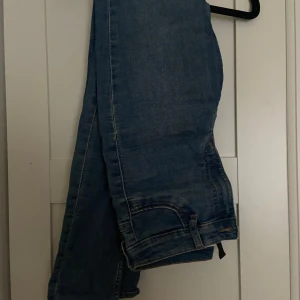 Blå jeans från H&M Divided - Snygga blå jeans från H&M Divided med hög midja och en tight passform. Säljs då de inte kommer till användning längre 