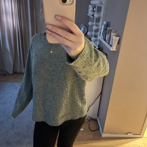 Grå stickad tröja - Mysig grå stickad tröja med långärmad design. Perfekt för kyligare dagar och enkel att matcha med olika outfits.