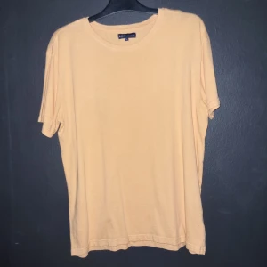 Orange t-shirt från S.C.W. - Säljer en stilren orange t-shirt från S.C.W. i storlek L. Perfekt för en avslappnad look med sin enkla design och mjuka material.