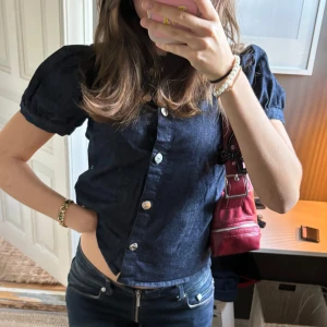 Mörkblå jeansblus med puffärmar - Säljer en snygg mörkblå jeansblus med puffärmar och knappar framtill. Använd fåtal gånger 