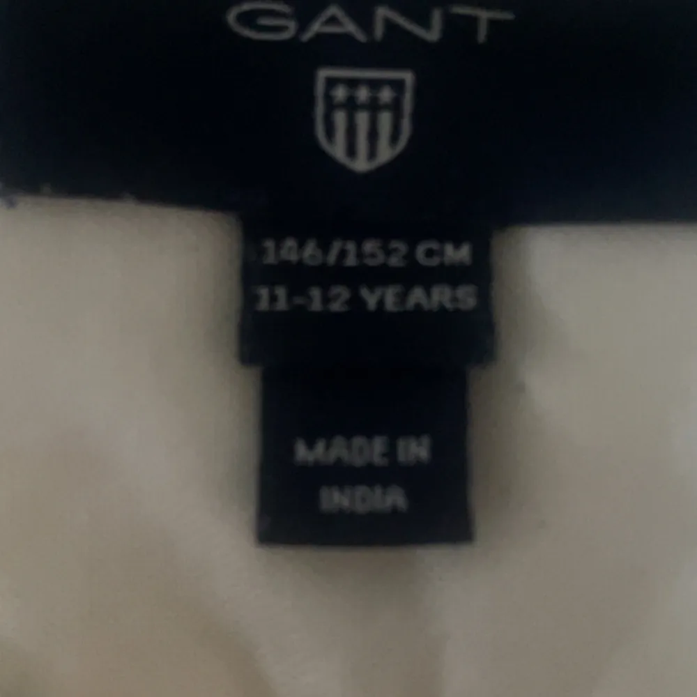 Säljer en klassisk vit långärmad skjorta från GANT. Skjortan har en broderad logga på bröstet och knappar framtill. Perfekt för en stilren look.. Paidat.