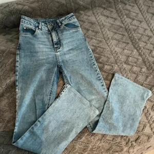 High waist petite bootcut jeans GinaTricot  - Ljusblåa high waist petite bootcut jeans från GinaTricot. Har slits i slutet av båda byxbenen. Skulle säga att midjan på byxorna sitter tajt.   Innerbensmått på byxorna är ungefär 70cm, förkortade de hos en skräddare.