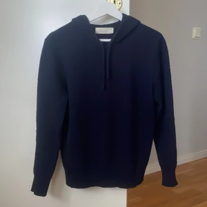 Kashmir hoodie från Sayless - Säljer en stilren mörkblå hoodie från Sayless i kashmir. Perfekt för kyliga dagar med sin mjuka och lyxiga känsla. Den har en klassisk design med långa ärmar och en bekväm huva. Passar perfekt för en avslappnad look. Den är i mycket bra skick.