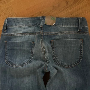 Blå bootcut jeans - Snygga blå bootcut jeans med klassisk femficksdesign. De har en knapp och dragkedja framtill. Perfekta för en avslappnad stil.