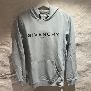 Ljusblå hoodie från Givenchy - Säljer en stilren ljusblå hoodie från Givenchy med svart logotyp på bröstet. Den är i väldigt bra skick och den har bara anvädts varsamt, pris kan diskuteras och var nu inte rädd att höra av dig vid några funderingar😉🤩🤩🍸🍾