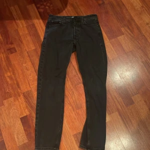 Svarta jeans från Jack & Jones - Snygga svarta jeans från Jack & Jones med en klassisk design. De har en rak passform och är tillverkade i ett slitstarkt material. Perfekta för en stilren look.