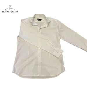 Vit skjorta från Riley - Klassisk vit skjorta från Riley i slim fit. Skjortan har långa ärmar och knappar framtill. Perfekt för en stilren look.