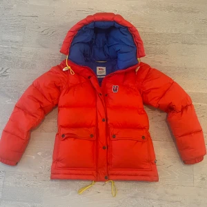 Röd/orange dunjacka från Fjällräven - Säljer min superfina röd/orange Expedition Down Lite jacka från Fjällräven. Jackan har blå insida och huva som inte finns i nuvarande kollektionen! Köpt 2021 eller 2022 på butiken. Säljer eftersom jag har en ny jacka! Jackan är i jättefint skick och har inga hål och har kemtvättats. Om ni vill ha fler bilder är det bara skriva. Kan även mötas upp i Stockholm! (Pris kan diskuteras)