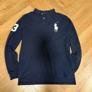 Mörkblå pikétröja från Ralph Lauren - Säljer en stilren pikétröja från Ralph lauren!🙌 skick 7-8-10(täcken på användning i nacklappen) Det finns inga dumma frågor bara att fråga på!🙌 Dunderpris på 369 kr, Obs! pris kan justeras vid snabb affär!