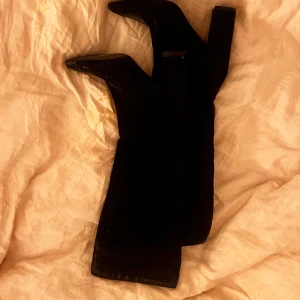 Svarta stövletter med klack - Snygga svarta stövletter med spetsig tå och klack. Perfekta för en elegant look. De är tillverkade i ett material som ger en stilren finish.