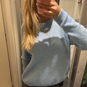 Ljusblå stickad tröja - Mysig ljusblå stickad tröja med långa ärmar och rund hals. Perfekt för kyligare dagar och ger en avslappnad stil. Passar bra till jeans eller kjol.