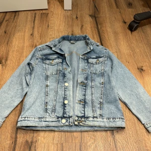 Ljusblå jeansjacka från H&M - Säljer en klassisk ljusblå jeansjacka från H&M Jackan har långa ärmar och knappar framtill samt två bröstfickor med lock. Perfekt för en avslappnad stil. 🧢👖