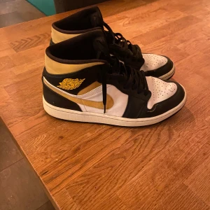 Jordan 1 - Hej, jag säljer ett par stiliga Jordan 1 som har färgerna svart, vitt och gul. Skorna har en klassisk och snygg design inom Jordan 1 kollektionen. Dem är väldigt bekväma och i väldigt bra skick men med en enstaka defekt (se bild i annonsen). Pris kan diskuteras! 
