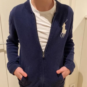 Mörkblå kofta från Ralph Lauren - Säljer en mörkblå tröja ifrån Ralph lauren, det är xl i barn storlek men passar s i vuxen. Säljer för har inte fått någon användning för den. 