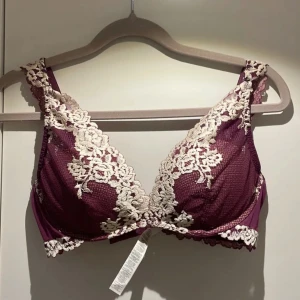 Intimissimi BH - Elegant vinröd Intimissimi bh med vacker spetsdetalj i vit. Bh:n har breda axelband och en fin spetskant som ger en romantisk känsla. Perfekt för att känna sig extra fin under kläderna. Som ny!