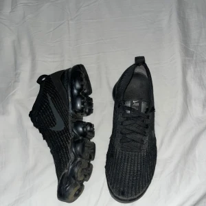 Svarta Nike Air Vapormax - Säljer ett par svarta Nike Air Vapormax. Skorna är i bra skick och funkar för både träning och vardag. Köpte dom för några år sedan och använde dom några gånger den sommaren. Nu säljer jag dom eftersom dom inte används längre. Vid mer frgåor så är det bara att skicka meddelande 
