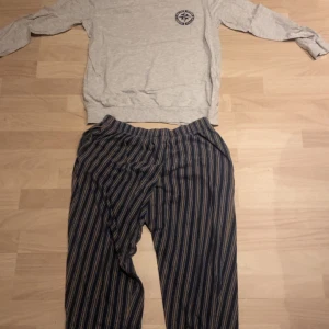 Randiga pyjamas byxor i bomull - Säljer ett par bekväma pyjamas ställ. Byxorna har en loose passform och elastisk midja för extra komfort. Perfekta för en avslappnad stil.