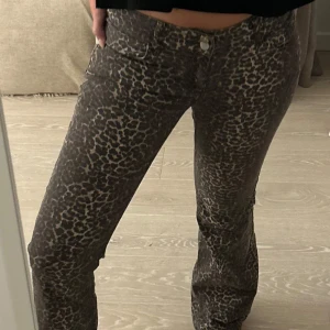 Leopardmönstrade byxor - Snygga och populära leopardmönstrade byxor från Nelly med en tight passform och utsvängda ben. Perfekta för att ge din outfit en djärv touch. Byxorna har en knapp och dragkedja framtill. Sparsamt använda inga defekter! 