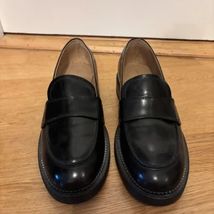 Svarta loafers i skinn - Snygga svarta loafers i skinn med en klassisk design. Stilrena med en låg klack. Använda endast en gång då dem är lite för små för mig. 