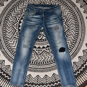 Blå jeans från Dsquared2 - Snygga blå jeans från Dsquared2 med slitna detaljer och en modern look. De har en klassisk femficksdesign och en knappgylf. Perfekta för en avslappnad stil med en touch av edge.