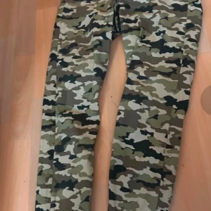 Camouflage cargopants - Snygga cargopants i klassiskt camouflagemönster. Perfekta för en avslappnad och cool stil. Byxorna har flera praktiska fickor och en bekväm passform. Skön stretch hög midja.