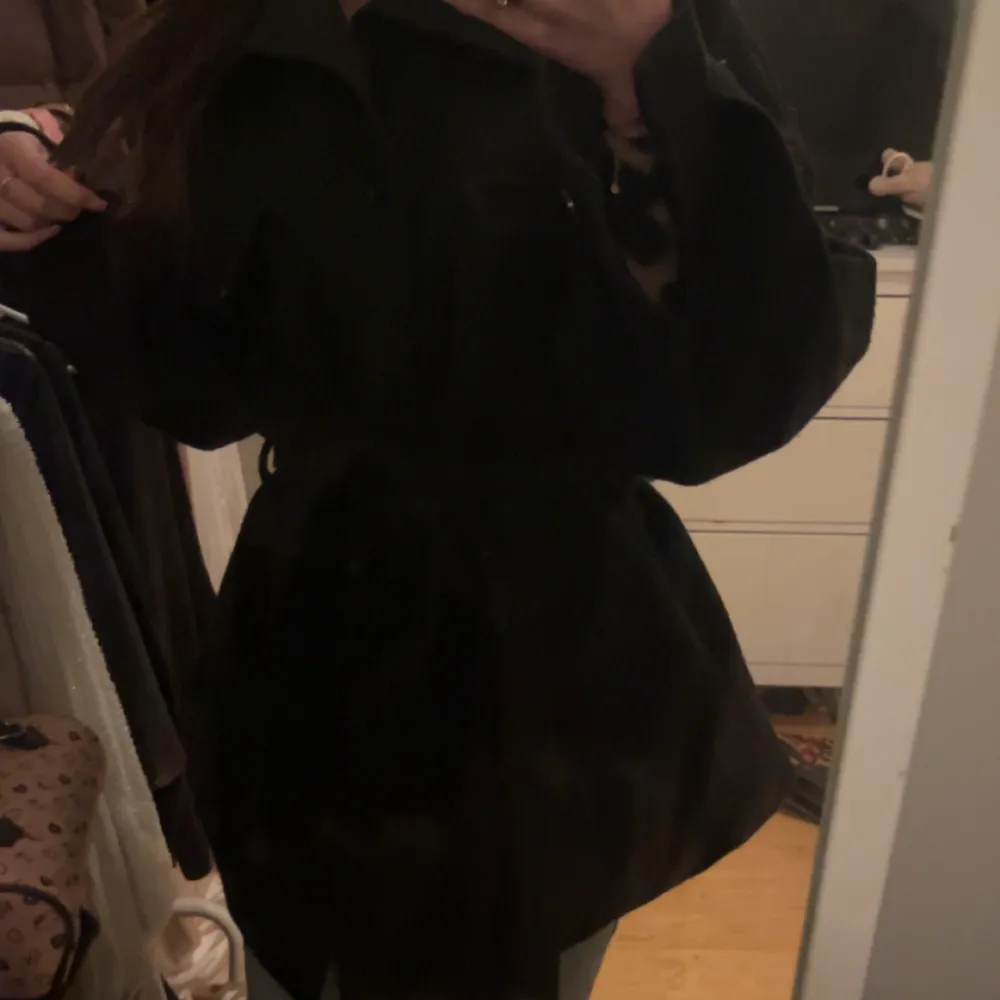 Snygg svart kappa från Boohoo med knytband i midjan. Perfekt för vår/höst och vinter med en varm tröja under🩷passar M/S. Takit.