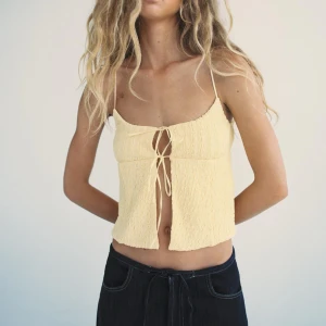 Zara gul linnetopp  - Snygg gul linnetopp från Zara med smala axelband och knytning framtill. Toppen har en texturerad yta och är perfekt för varma sommardagar. Den är helt ny och oanvänd💓