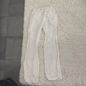 Vita linnebyxor - Snygga och luftiga vita linnebyxor med elastisk midja. Perfekta för varma dagar med sin lätta och bekväma passform. Byxorna har en avslappnad stil och passar bra till både vardag och semester.