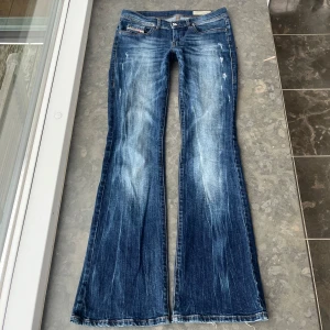 Disel bootcut jeans med slitningar  - Jätte snygga jeans med slitningar!! Lågmidjade & bootcut/utsvängda. Sitter jätte snyggt och är sjukt eftertraktade!!🥰 Midjemått= 41 cm ( med stretch) Midje höjd= 20 cm (lågmidjade!) Innerbenslängd=81 cm ❤️Ett litet, minimalistiskt, hål vid midjan men som verkligen inte syns. 